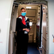 A cabin crew member wearing a protective face mask waits at the entrance of a Brussels Airlines plane, at Brussels Airport, in Zaventem, on June 15, 2020 as Brussels Airport reopens for travels within Europe and the Schengen zone, after a months-long closure aimed at stemming the spread of the COVID-19 pandemic, caused by the novel coronavirus.